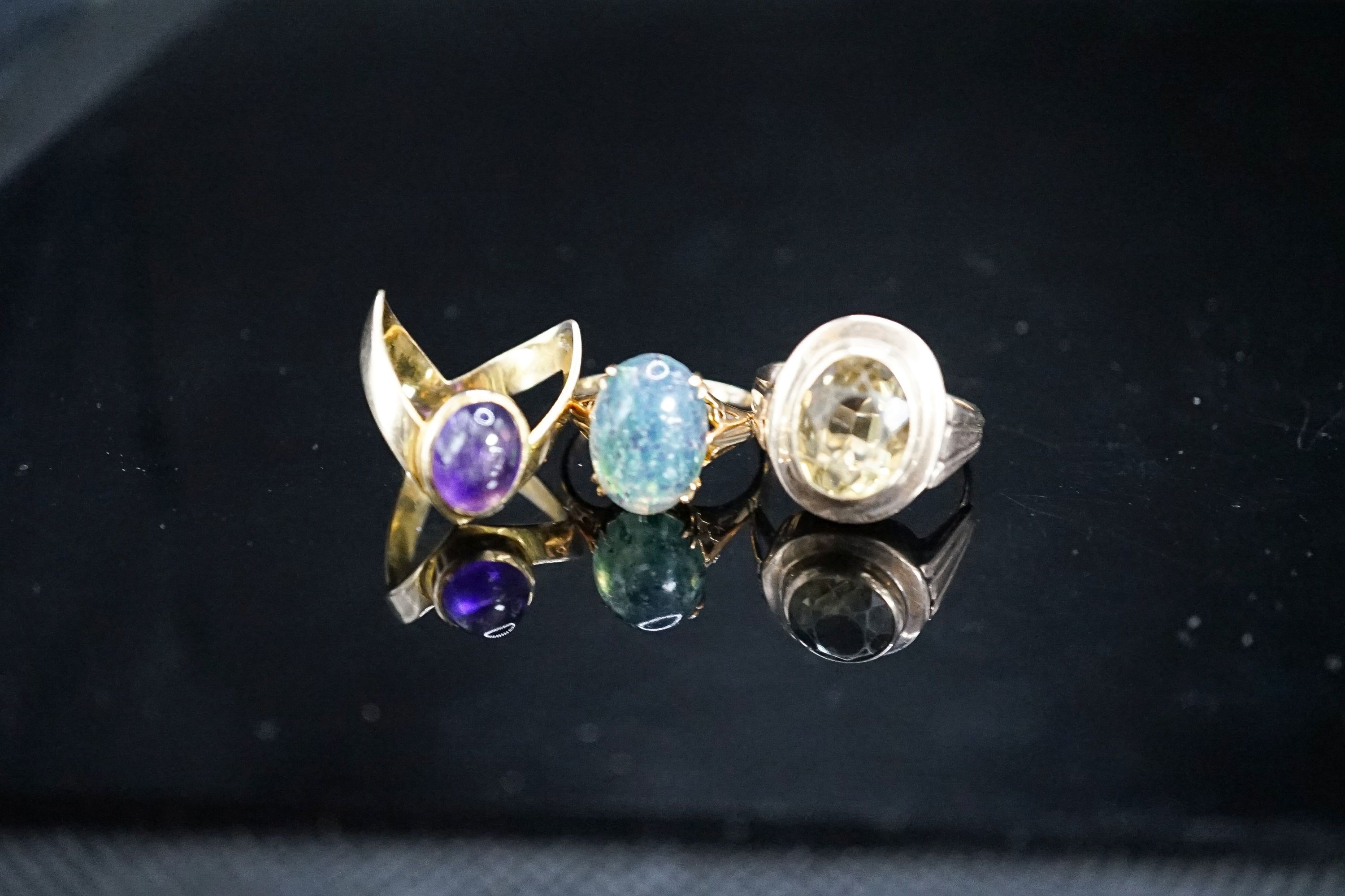 Two 9ct and gem set dress rings, gross 6.8 grams and a 333(8ct) and gem set dress ring, gross 5.6 grams.